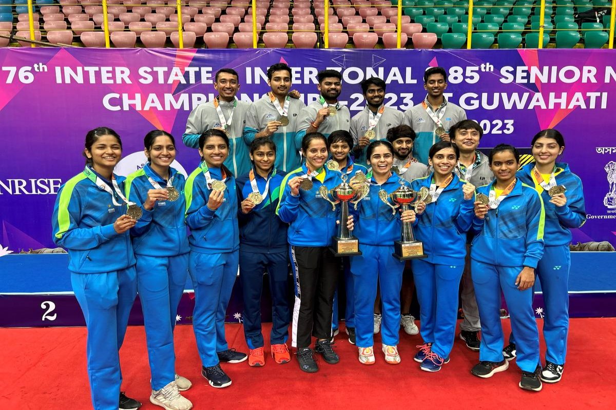 Tennis player serving the ball on a clay court during sunset